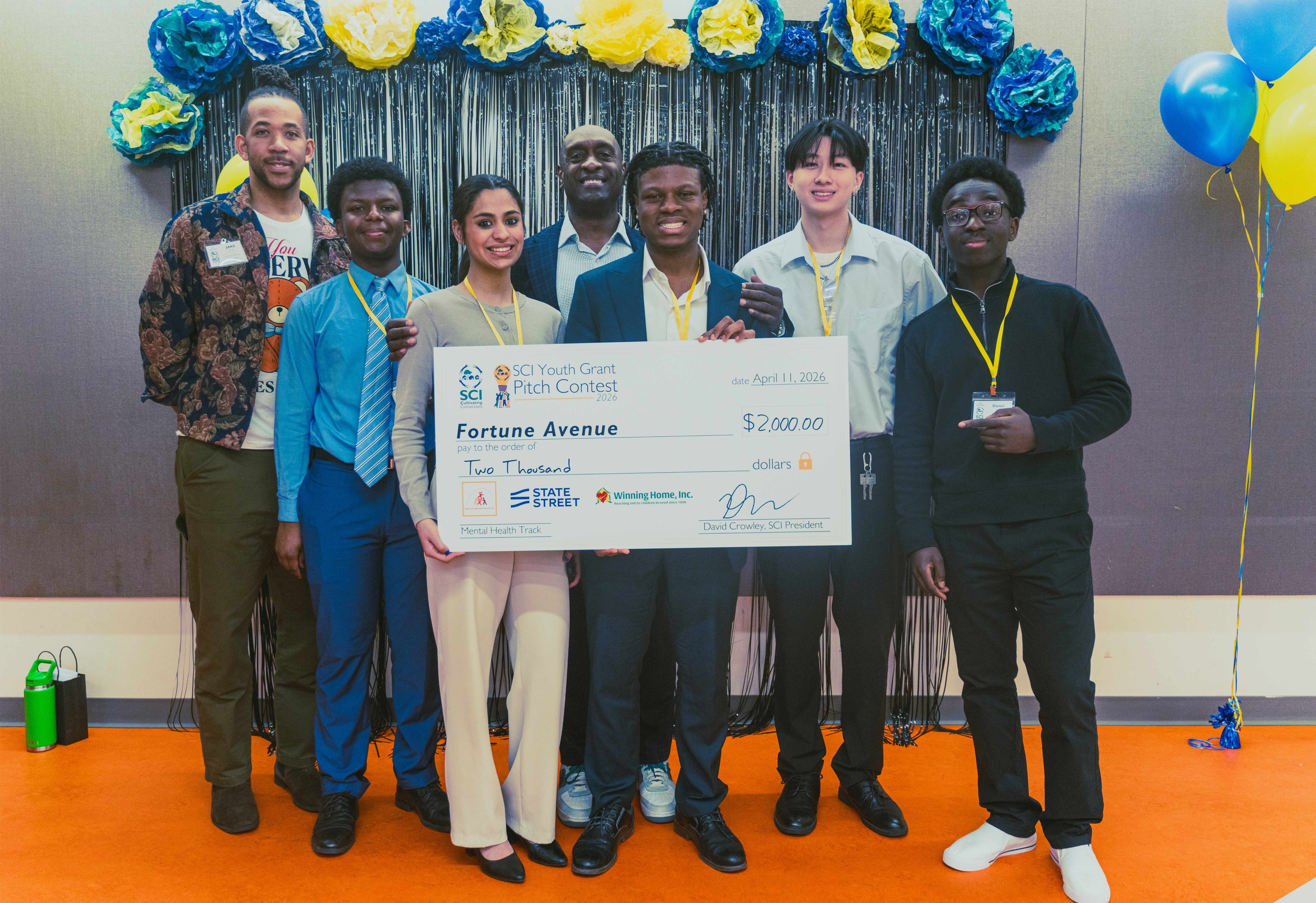 Fortune Avenue youth members (left to right) Elamin Elamin, Rebecca John, Daniel Idenudia, David Huang, and Daniel David pose with Team Advisor, JAKE Small (left) and Mental Health Track Judge, Seth Libert (background, center).