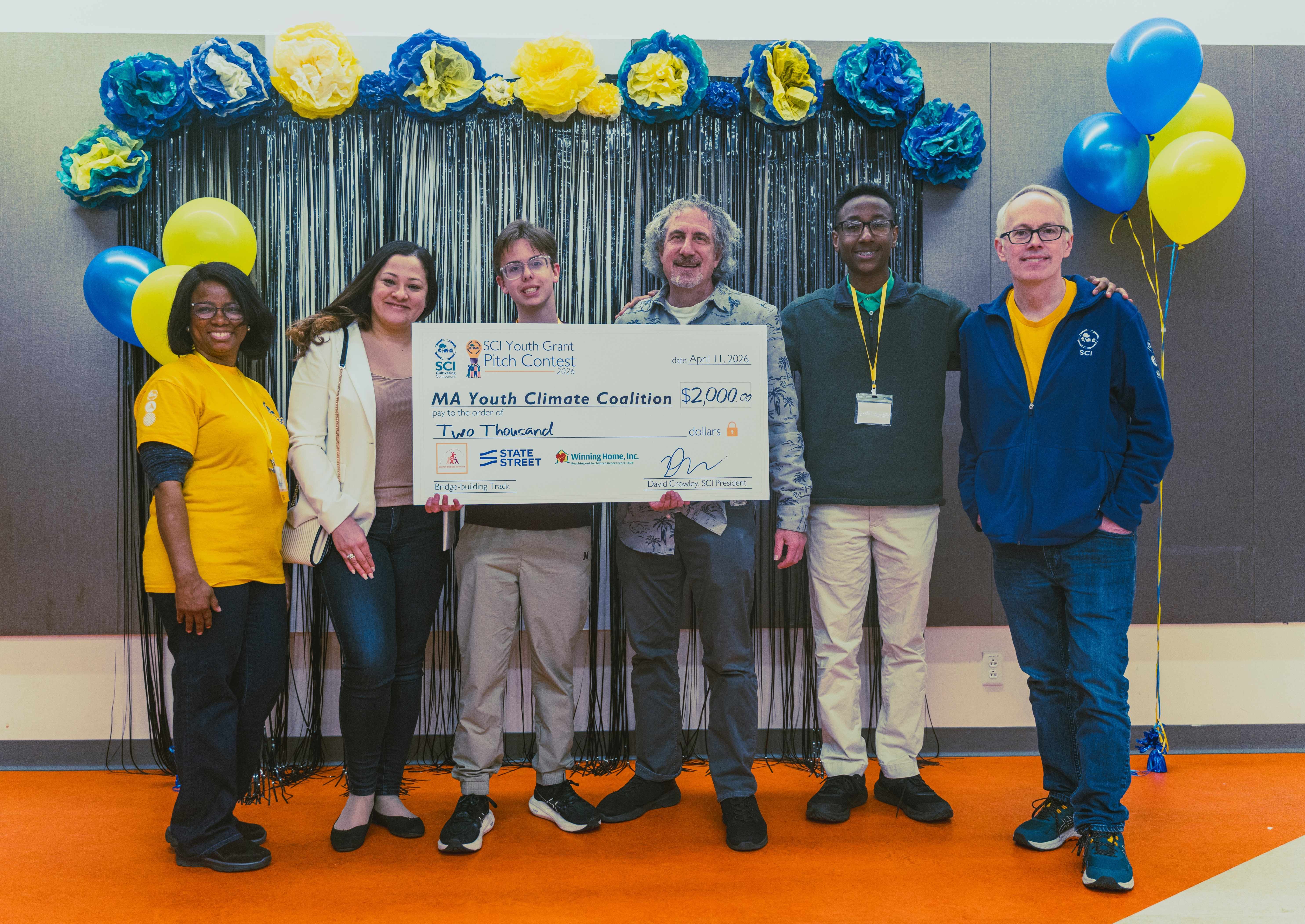 MA Youth Climate Coalition youth leaders, Rylan Workman (center-left) and Kidus Tsige (second from right), pose with Pitch Coaches, Jolly Pradhan (second from left) and Jack Nedelman (center-right); SCI Program Coordinator, Vitalie Memeus (left); and SCI President, David Crowley (right).