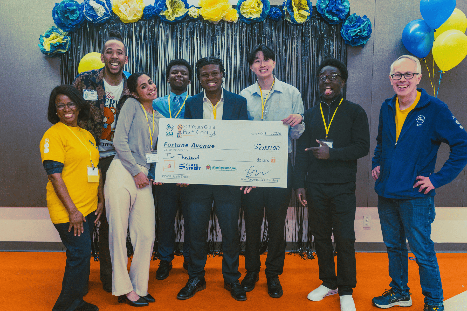 Caption: Fortune Avenue youth members, advisor, and SCI staff posed with the team’s grant award of $2,000. Pictured left to right are SCI Program Coordinator Vitalie Memus, Team Advisor JAKE Small; team members Rebecca John, Elamin Elamin, Daniel Idenudia, David Huang, and Daniel David; and SCI President David Crowley.